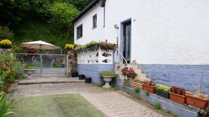 A house with a paved patio, a lawn, and flower pots on the steps. - Am Dohlenberg by Interhome (Schwalenberg)