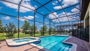 Piscina com cobertura de vidro, rodeada por um pátio de tijolos.