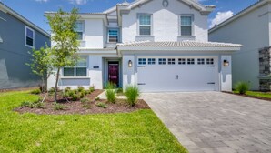 A two-story house with a garage, a well-maintained lawn, and a clear sky. - 6 Bedroom 5 Bathroom 9045hs (Davenport)