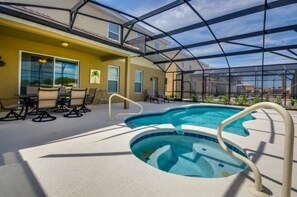 An indoor swimming pool with a glass enclosure, lounge chairs, and a view of the surrounding area. - Solterra Resort Villa (Davenport)