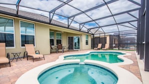 Un espace extérieur abrité avec une piscine, des chaises longues et une table de patio.