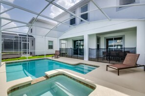 A modern indoor pool area with clear glass walls, a hot tub, and seating areas. - 6 Bedroom 5 Bathroom Villa 1573sw (Davenport)