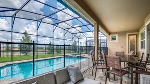 Une terrasse couverte avec une piscine, du mobilier d’extérieur et une vue sur le paysage environnant.