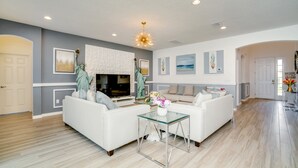 A modern living room with a white sofa, glass coffee table, and a fireplace. - 6121bod 11 Bedroom 9 Bathroom (Davenport)
