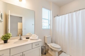 A bathroom with a sink, mirror, toilet, and shower curtain. - 10 Bedroom 8 Bathroom Sonoma Resort Villa 2619ca (Kissimmee)