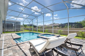 Una piscina cubierta al aire libre con sillones de descanso y un jacuzzi.
