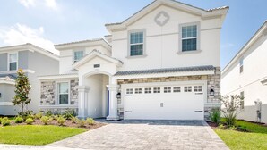 A two-story house with a white exterior, a stone facade, and a garage.