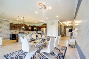 Une cuisine moderne avec des meubles en bois foncé, un îlot central et des luminaires suspendus.