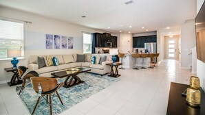A spacious living room with a sectional sofa, a coffee table, and a dining area with chairs. - 9003pct New Amazing 7 Bedroom 5 Bathroom Villa (Kissimmee)