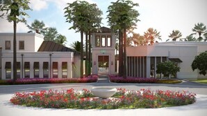 A modern building with a central tower, surrounded by landscaped gardens and palm trees. - 9003pct New Amazing 7 Bedroom 5 Bathroom Villa (Kissimmee)