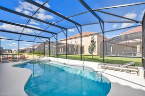 A swimming pool with a glass enclosure, surrounded by a white deck and lounge chairs. - 7013ows 14 Bed 11 Bathroom (Davenport)