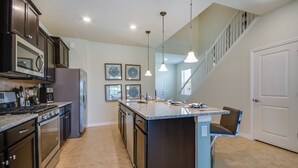 A modern kitchen with dark cabinetry, stainless steel appliances, and a central island. - 5569misty Luxury 7 Bedroom Pool Villa (Davenport)
