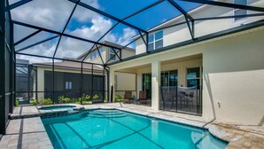 A swimming pool with a glass ceiling, surrounded by a patio area with chairs and a small garden. - Orlando Newest Resort Villa With Pool 1791spp (Kissimmee)