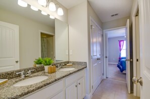 A bathroom with two sinks, a large mirror, and a potted plant. - Ultimate 6 Bedroom 5 Bathroom Solterra Resort Home (Davenport)