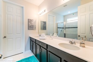 A modern bathroom with two sinks, a large mirror, and dark cabinetry. - Amazing 7 Bd 5 Ba Villa Solara Resort 1600hgp (Kissimmee)