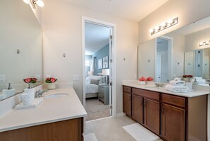 A modern bathroom with two sinks, a large mirror, and vanity cabinets. - Amazing 6 Bedroom 5 Bathroom Solara Resort Villa (Kissimmee)
