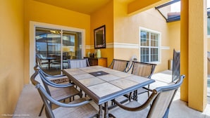 A dining area with a table and chairs, a window, and a door leading to another room. - Cuban Place 8963 Paradise Plams (Kissimmee)