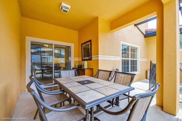 A dining area with a table and chairs, a window, and a door leading to another room.