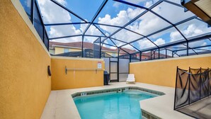 An indoor swimming pool with a glass ceiling, a lifeguard chair, and a safety sign. - Cuban Place 8963 Paradise Plams (Kissimmee)