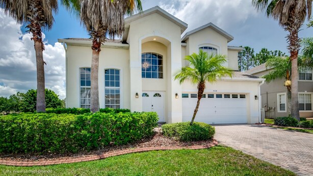A two-story house with a garage, surrounded by well-maintained landscaping and palm trees. - Luxury 5 Bedroom 4 Bath Villa With Bespoke 468bel (Davenport)