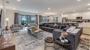 Ein modernes Wohnzimmer mit einer Couch, einem Couchtisch und einem Essbereich mit Stühlen.