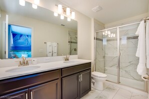A modern bathroom with dual sinks, a large mirror, and a glass shower enclosure.