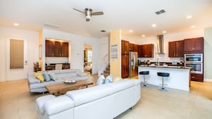A modern kitchen with wooden cabinets, a stainless steel refrigerator, and a built-in oven.