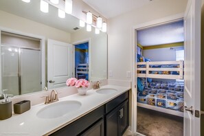 A bathroom with two sinks, a large mirror, and a vanity with a vase of flowers. - 1571pw Amazing Champions Gate 6 Bedroom 6 Bed (Davenport)