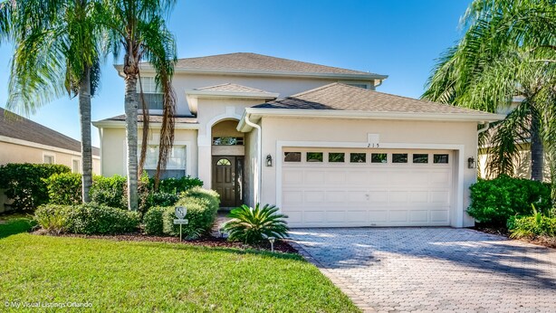 A two-story house with a garage, surrounded by well-maintained landscaping and palm trees. - 215glen Amazing Newly Decorated 5 Bedroom (Davenport)