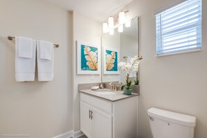 A bathroom with a white sink, mirror, and toilet. There are two towels hanging on a towel bar. - 910pb Luxury Furnished 5 Bedroom 5 Bathroom (Davenport)