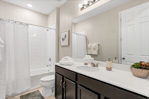 A modern bathroom with a bathtub, toilet, and sink.