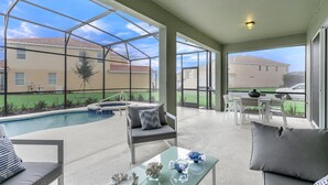 Un espacio exterior cubierto con piscina, asientos y vistas a edificios cercanos.