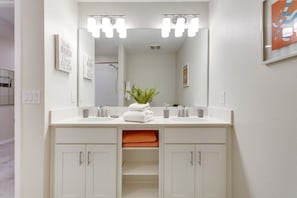 A bathroom with a white vanity, two sinks, a mirror, and a plant. - 3111u307 Amazing Story Lake Brand New Condo (Kissimmee)