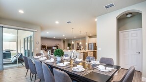A dining area with a long table set for six, surrounded by chairs. - Broad Oak Villa Solterra 3 (Davenport)