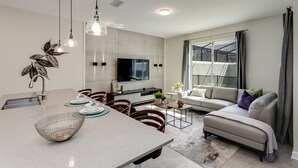 Eine moderne Küche mit Essbereich, einer Couch und einem großen Fenster.
