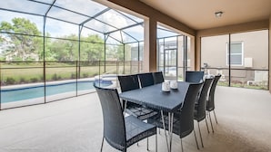A covered patio with a pool view, outdoor seating, and a large window. - Oakbrone Avenue Villa Solterra 3 (Davenport)