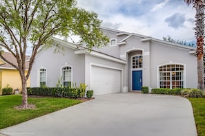 A single-story house with a white exterior, a blue front door, and a garage.