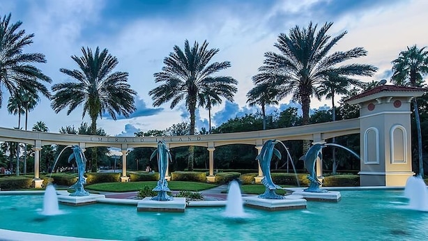 A pool with multiple fountains, palm trees, and a gazebo with the text "Emerald Isle". - 2782skp Emerald Island Resort (Kissimmee)