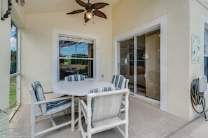 A patio with a table and chairs, a ceiling fan, and a sliding glass door leading to a covered area. - 234glen Fantastically Decorated 4 bed 2 Bath (Davenport)