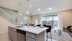 A modern kitchen with a central island, stainless steel appliances, and pendant lighting. - 8916sydney Fantastic 5 Bed 4 Bathroom Town Home (Kissimmee)