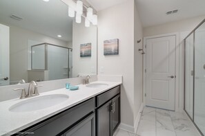 A modern bathroom with two sinks, a large mirror, and a glass shower enclosure. - 891pbeach Amazing Champions Gate 9 Bedroom 5 Bed (Davenport)