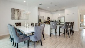 A modern kitchen with white cabinets, stainless steel appliances, and a central island. - 518mb New and Modern 8 Bedroom 5 Bathroom Villa (Kissimmee)
