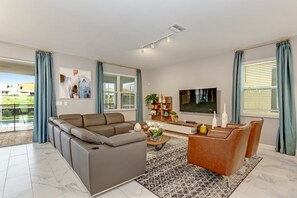 Una sala de estar moderna con un sofá modular, una mesa de centro y un televisor.