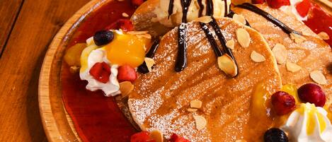 Une assiette de dessert avec des crêpes, de la glace et divers fruits.