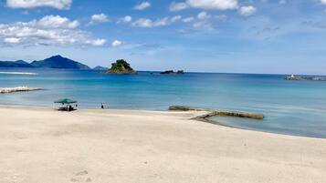 Pantai di sekitar, pasir putih, kursi berjemur, dan payung pantai