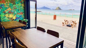 A dining area with a view of a beach and ocean. - Beach Side Village Familiar - Hostel (Takahama)
