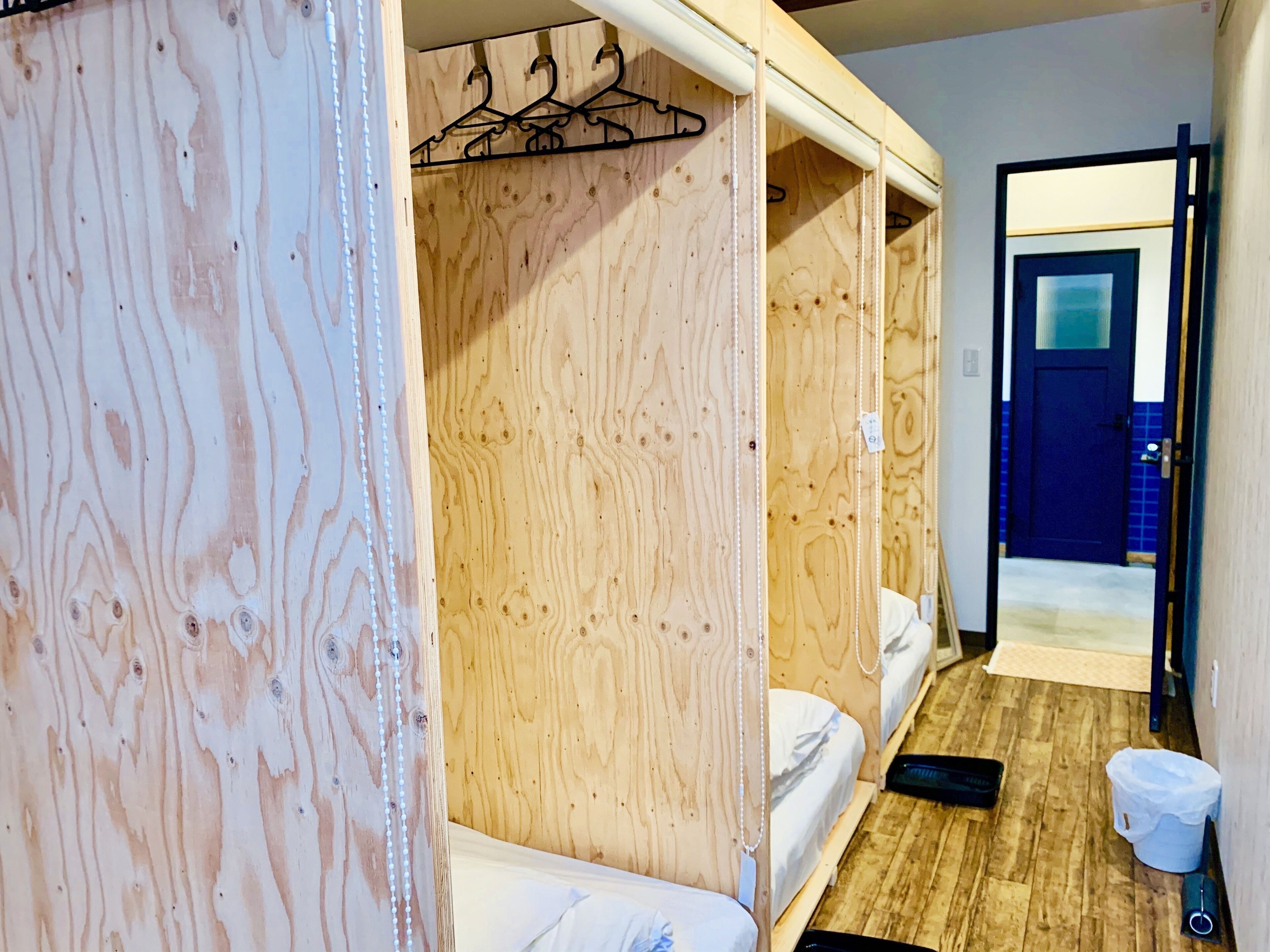 Una habitación de madera con literas, un armario de madera y una puerta azul.