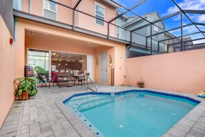 A two-story house with a swimming pool, a covered patio, and a dining area.