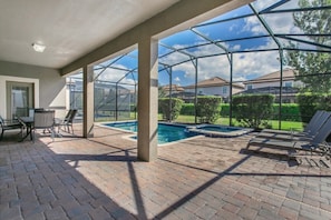 A covered patio area with a pool, outdoor seating, and a view of the neighborhood. - Rolling Fairway Villa Champions Gate 3 (Davenport)