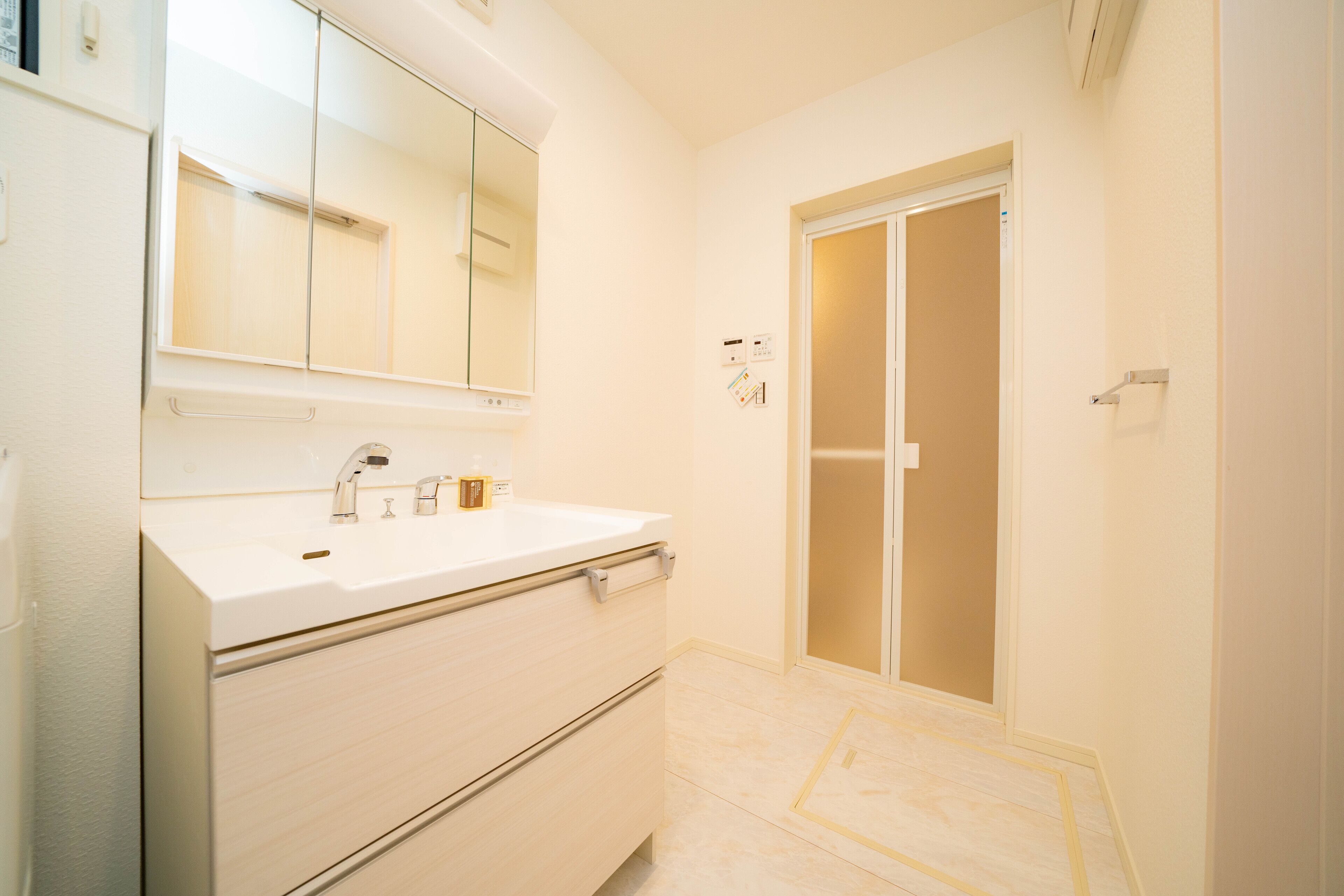 A bathroom with a white sink, mirror, and cabinet, and a sliding door closet.